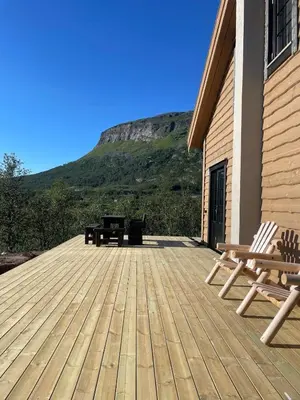 a deck with two benches and a picnic table at Fjellperlen, Hardangervidda in Eidfjord