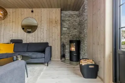 a living room with a couch and a fireplace at Fjellperlen, Hardangervidda in Eidfjord