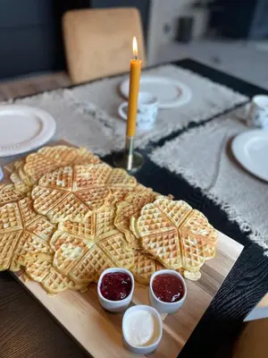 a wooden cutting board with cookies and a candle at Fjellperlen, Hardangervidda in Eidfjord