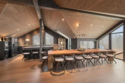 a dining room with a large wooden table and chairs at NEW cozy and large lodge with private Jacuzzi and sauna in Eggedal