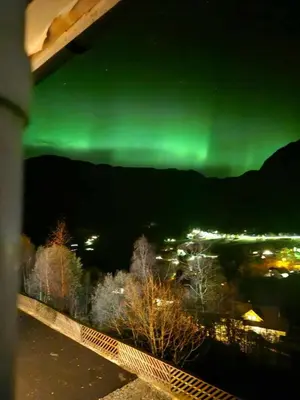 a view of the green northern lights over a city at Utsikten in Masfjorden