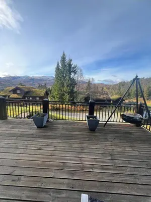 a wooden deck with two benches and a swing at Cabin in Kvamskogen in Kvam