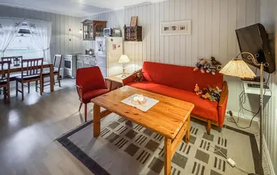 a living room with a red couch and a table at Amazing Apartment In Braskereidfoss With Wifi in Braskereidfoss