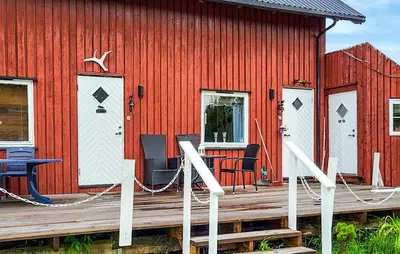 a red building with a wooden deck in front of it at Amazing Apartment In Braskereidfoss With Wifi in Braskereidfoss