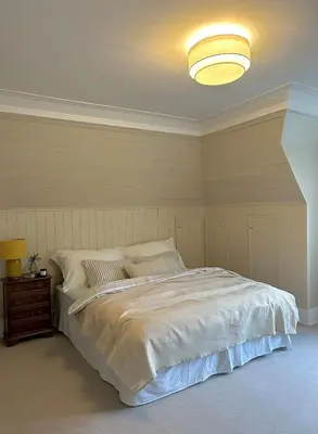 a bedroom with a large white bed with a light at Historic villa with large garden in Stord