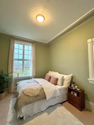 a bedroom with a bed and a window and a table at Historic villa with large garden in Stord