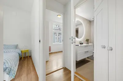a bedroom with a bed and a sink and a mirror at Central 3-room apartment in Trondheim
