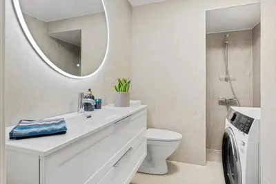 a bathroom with a sink and a toilet and a mirror at Central 3-room apartment in Trondheim