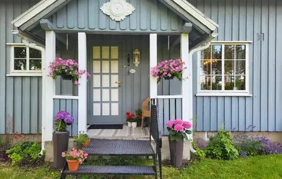 a blue house with flowers on the front door at Nice Home In Braskereidfoss With Wifi in Braskereidfoss