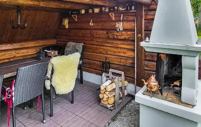 a patio with chairs and a fireplace in a cabin at Nice Home In Braskereidfoss With Wifi in Braskereidfoss