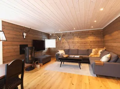 a living room with a couch and a tv at Stranda Fjellgrend 3 bedrooms - 98A in Stranda