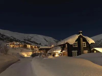 a house is covered in snow at night at Stranda Fjellgrend 3 bedrooms - 98A in Stranda