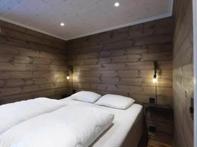a bed with two pillows in a room with wooden walls at Stranda Fjellgrend 3 bedrooms - 98A in Stranda