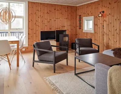 a living room with a table and chairs and a tv at Stranda Fjellgrend 2 bedrooms - 35c in Stranda