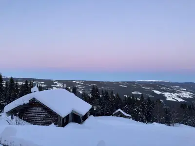 a log cabin covered in snow on a mountain at Apartment in Gol Skisenter in Gol