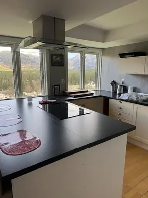 a kitchen with a black counter top and some windows at Spacious and luxurious house with stunning views in Vossevangen