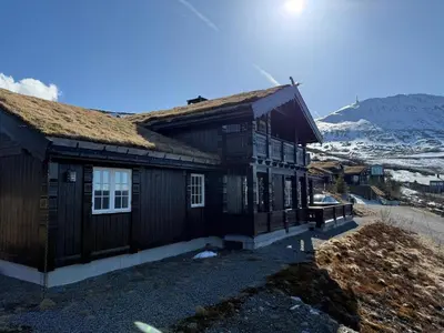 a wooden house with a grass roof on a mountain at Rustik hytte i Gausta, ski in, ski out, 10 beds in Gaustablikk
