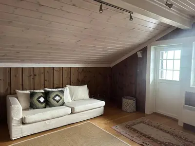 a living room with a white couch with pillows on it at Rustik hytte i Gausta, ski in, ski out, 10 beds in Gaustablikk