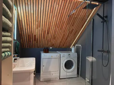 a bathroom with a washing machine and a washer at Cozy Apartment Next to Solsiden in Trondheim