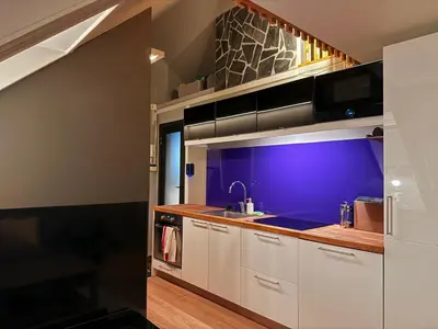 a kitchen with white cabinets and a sink at Cozy Apartment Next to Solsiden in Trondheim