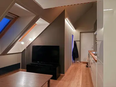 a living room with a flat screen tv in an attic at Cozy Apartment Next to Solsiden in Trondheim