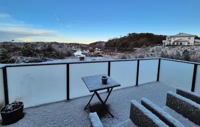 a table on a balcony in the snow at Awesome Apartment In Finnås With House Sea View in Vinnes