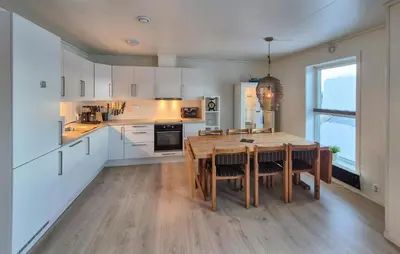 a kitchen with a wooden table and a dining room at Awesome Apartment In Finnås With House Sea View in Vinnes