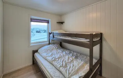 a small room with two bunk beds and a window at Awesome Apartment In Finnås With House Sea View in Vinnes
