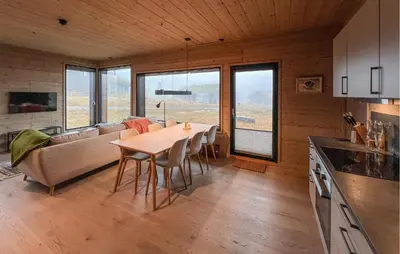 a kitchen and living room with a table and a couch at Amazing Apartment In Øyer With Wifi in Øyer