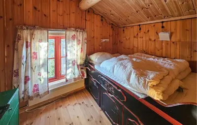 a bed in a wooden room with a window at Stunning Home In Austbygda With Wifi in Austbygdi