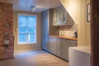 a kitchen with white cabinets and a window at Sentralen in Trysil