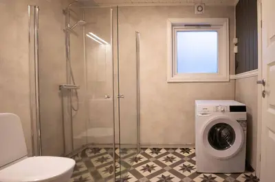 a bathroom with a shower and a washing machine at Sentralen in Trysil