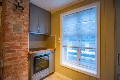 a kitchen with a window and a brick wall at Sentralen in Trysil