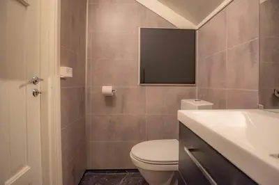 a bathroom with a toilet and a sink and a mirror at Sentralen in Trysil