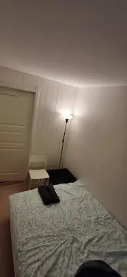 a bedroom with a bed and a lamp in a room at Guesthouse centrum location in Lii