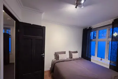 a bedroom with a bed and a large window at Cozy 2BD apartment in Central Bergen in Bergen