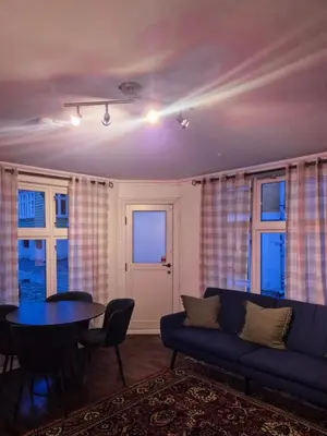 a living room with a couch and a table and windows at Cozy 2BD apartment in Central Bergen in Bergen