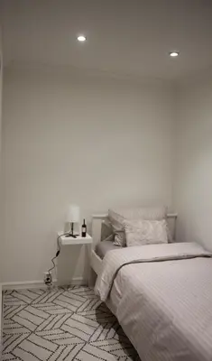 a white bedroom with two beds and a night stand at Cozy 2BD apartment in Central Bergen in Bergen
