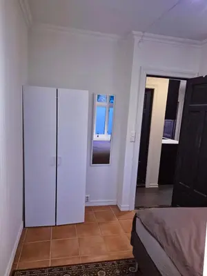 a room with a white cabinet and a bedroom at Cozy 2BD apartment in Central Bergen in Bergen