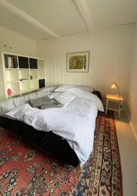 a bedroom with a large bed with a rug at Historic Timber Cabin With Views Of Rondane in Furuhovde