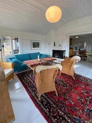 a living room with a blue couch and chairs at Historic Timber Cabin With Views Of Rondane in Furuhovde