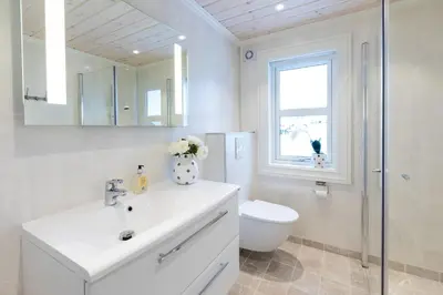 a bathroom with a sink and a toilet and a mirror at Stranda Fjellgrend 2 bedrooms and loft - 16B in Stranda