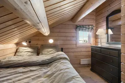a bedroom with a bed in a wooden cabin at Timber Cabin With Panoramic Views At Spåtind in Etnedal