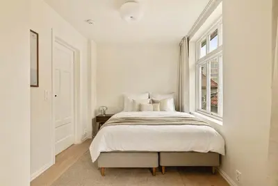 a white bedroom with a bed and a window at Modern 1BR in heart of old town in Bergen