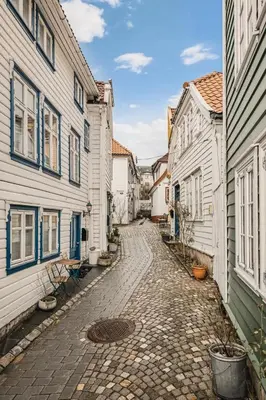 a cobblestone street in a town with white buildings at Modern 1BR in heart of old town in Bergen