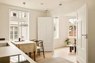 a kitchen and dining room with a table and chairs at Modern 1BR in heart of old town in Bergen