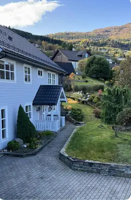 a white house with a garden and a house at Ski slopes nearby - Parking & WiFi in Vossevangen