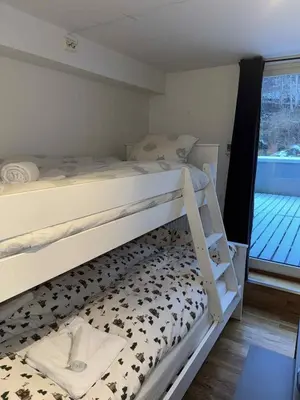 a bedroom with two bunk beds and a balcony at Lake Resort - Pool & Sauna in Vossevangen