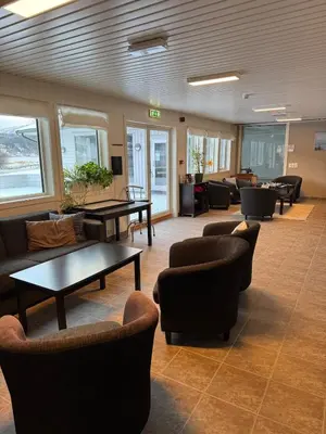 a waiting room with couches and tables and chairs at Lake Resort - Pool & Sauna in Vossevangen