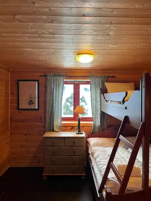 a bedroom with a bunk bed in a log cabin at Authentic Norwegian Cabin - Sauna, Firehouse & Nature in Vossevangen